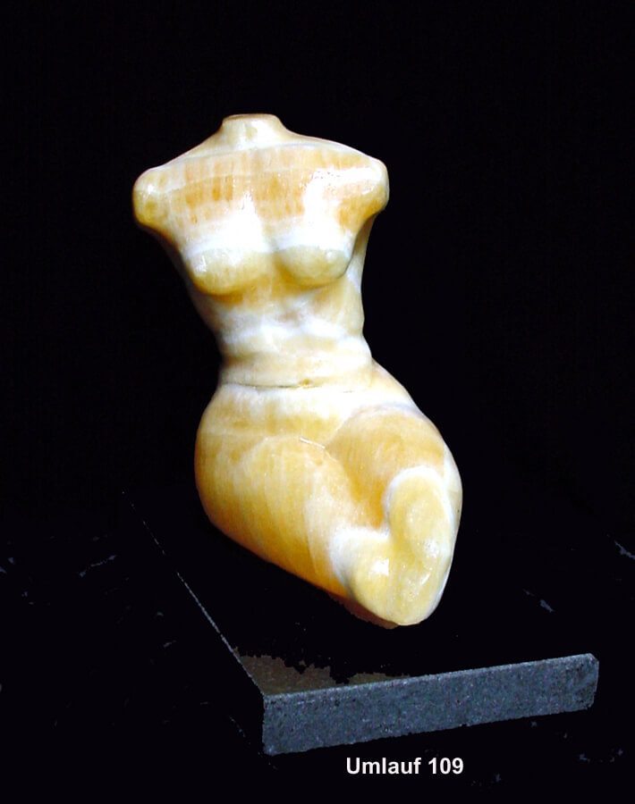 A small statue of a woman 's body on display.