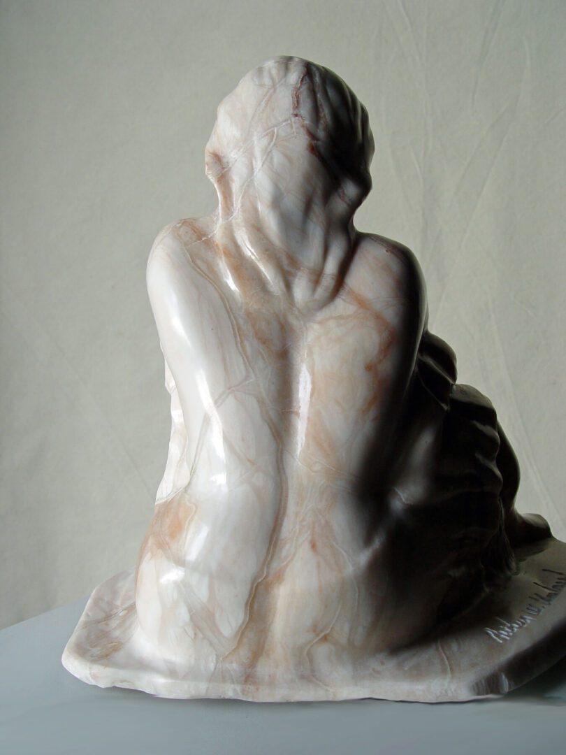 A marble statue of a woman sitting on top of a table.