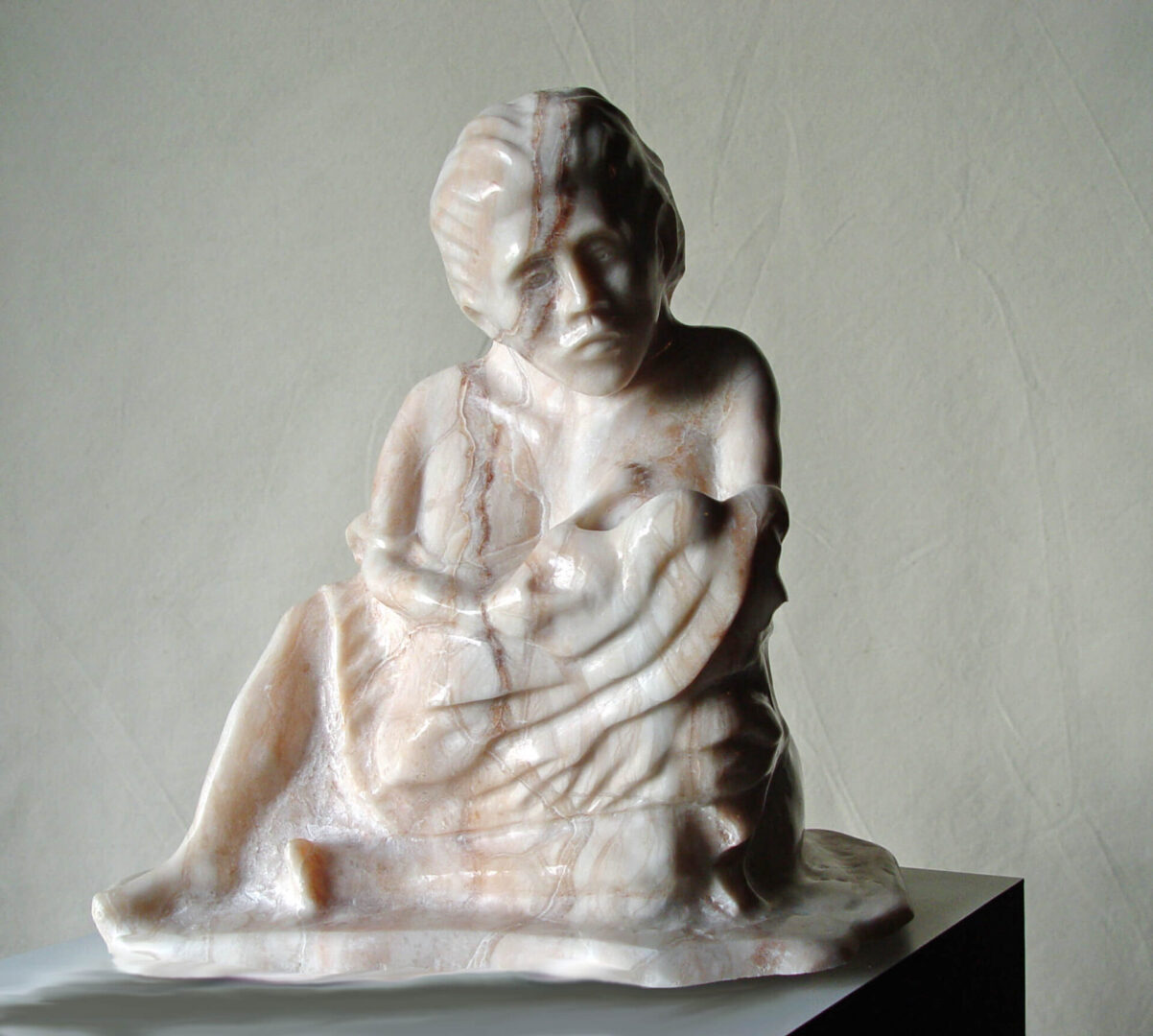 A marble statue of an old man holding a baby.