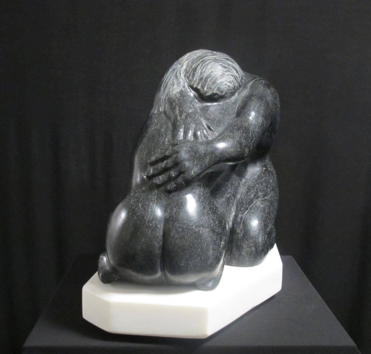 A sculpture of two monkeys sitting on top of a table.