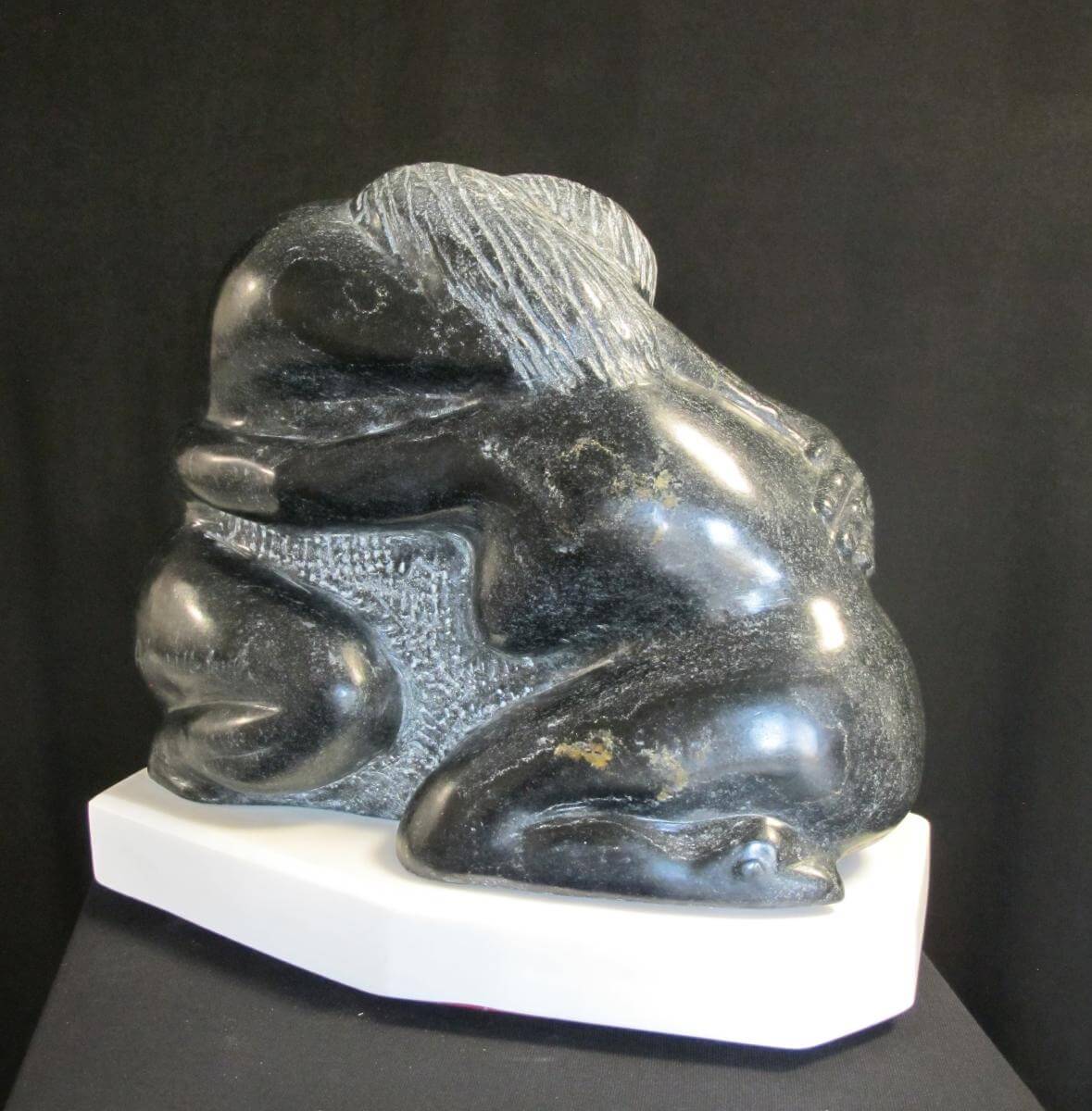 A sculpture of three animals sitting on top of each other.