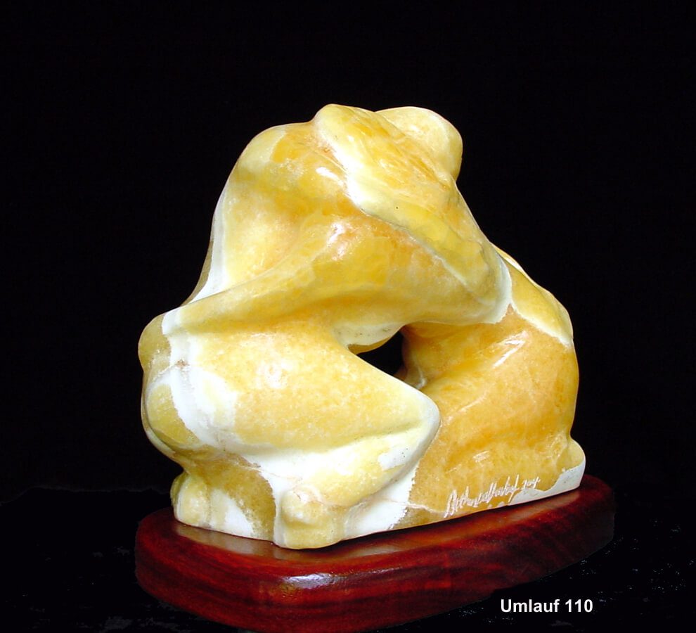 A yellow marble sculpture on a wooden stand.