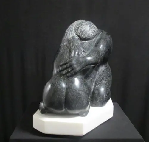 A black and white statue of two people hugging