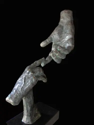 A sculpture of two hands holding each other.
