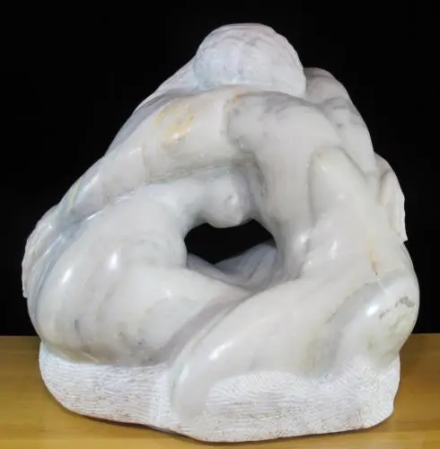 A marble sculpture of two people sitting on one another.