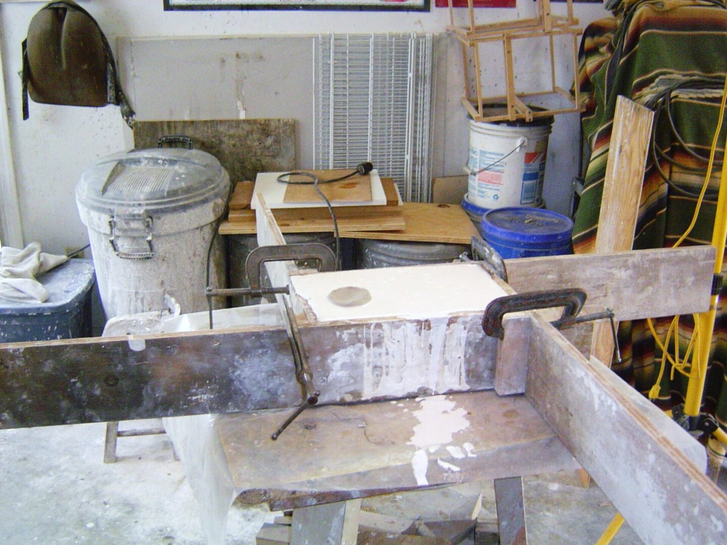 A piece of wood on a workbench used for making a Mother Mold.