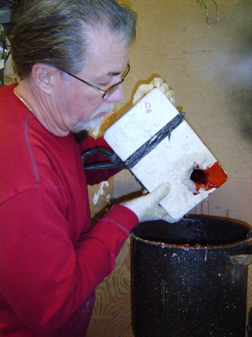 A man making a mother mold while wearing a red shirt.