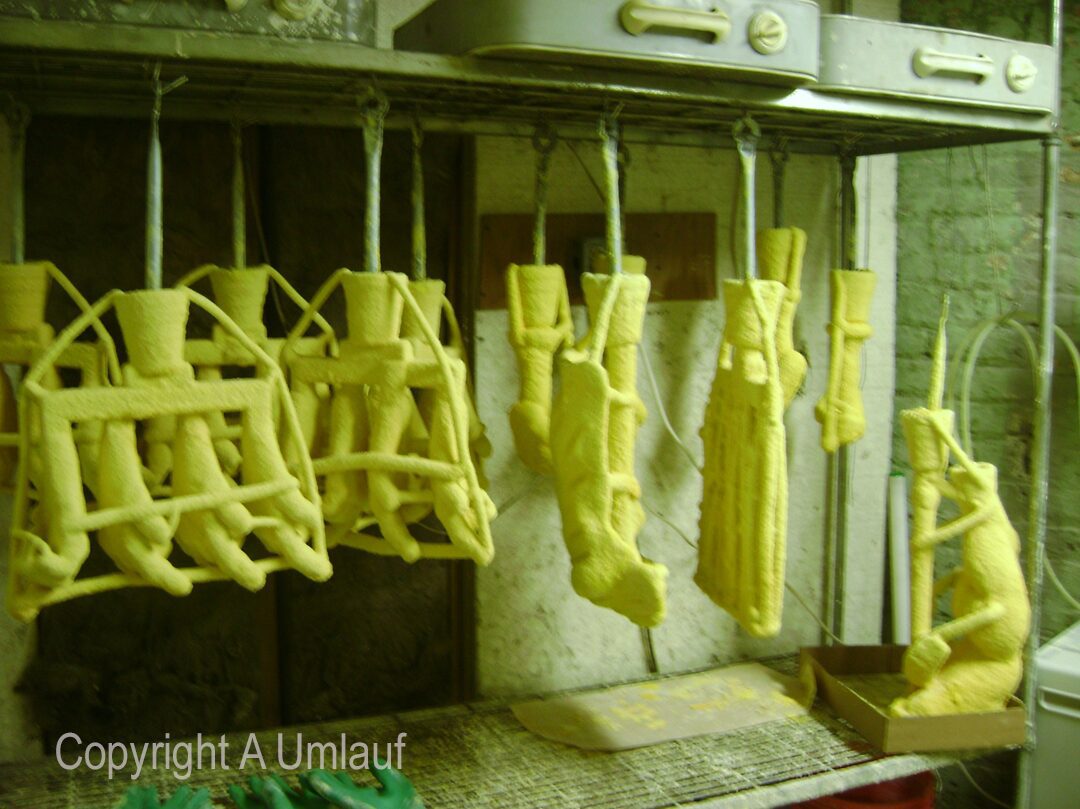 A kitchen with a lot of different kinds of food hanging on the racks, displayed in ceramic shell molds.