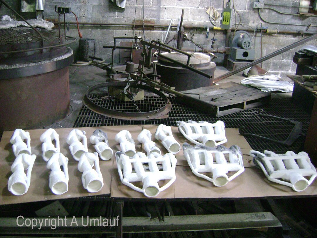 A group of white pieces of equipment on a table in a factory using the Ceramic Shell Mold Process.