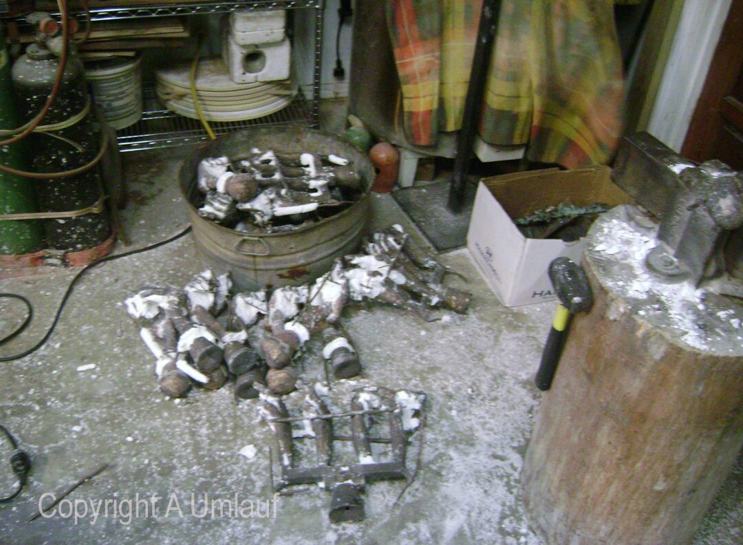 A room with a lot of tools and ceramic shell molds on the floor.