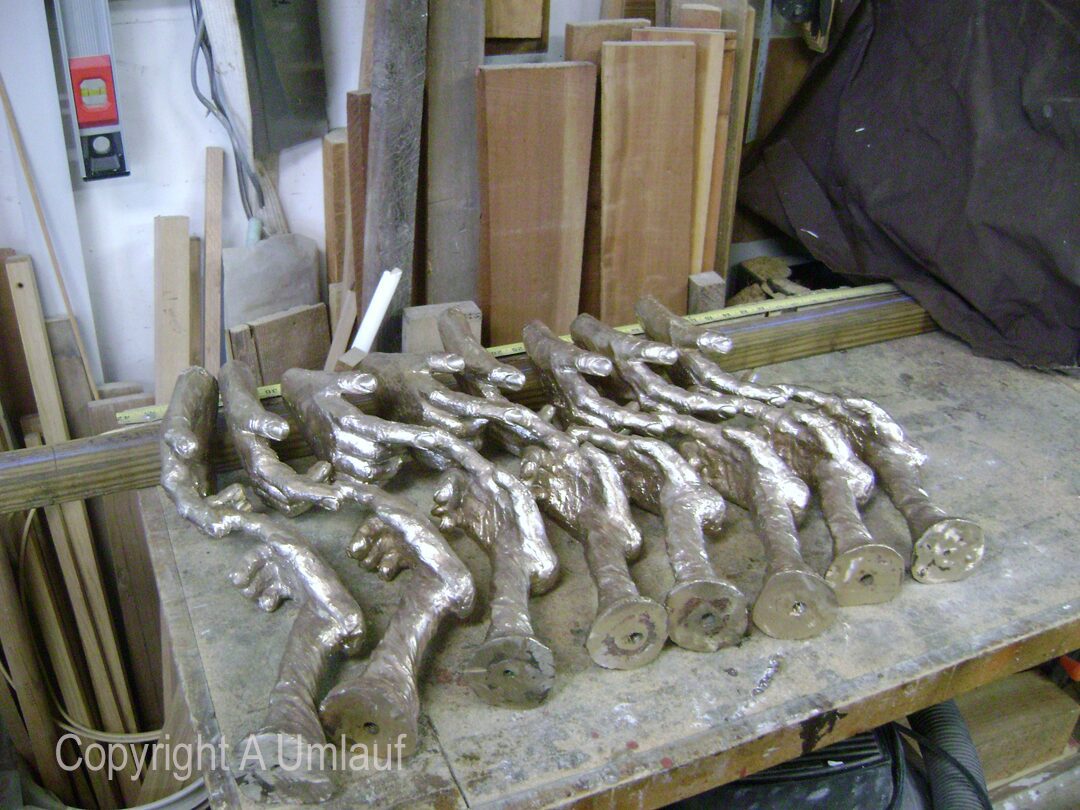 A group of metal pieces on a table in a workshop being prepared for the Ceramic Shell Mold Process.