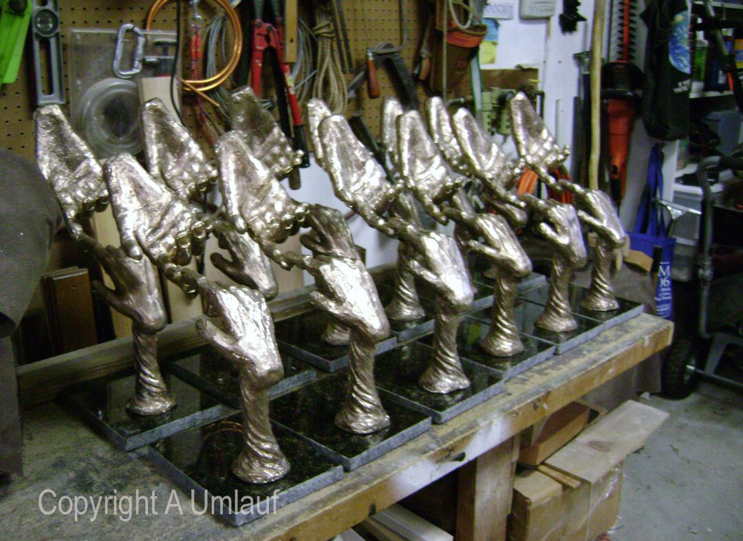 A group of ceramic trophies sitting on a table in a workshop.