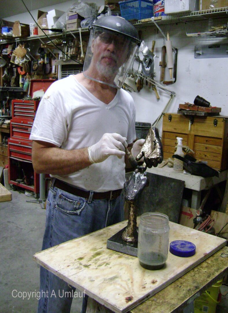 A man wearing a helmet is seen working in a workshop utilizing the Ceramic Shell Mold Process.
