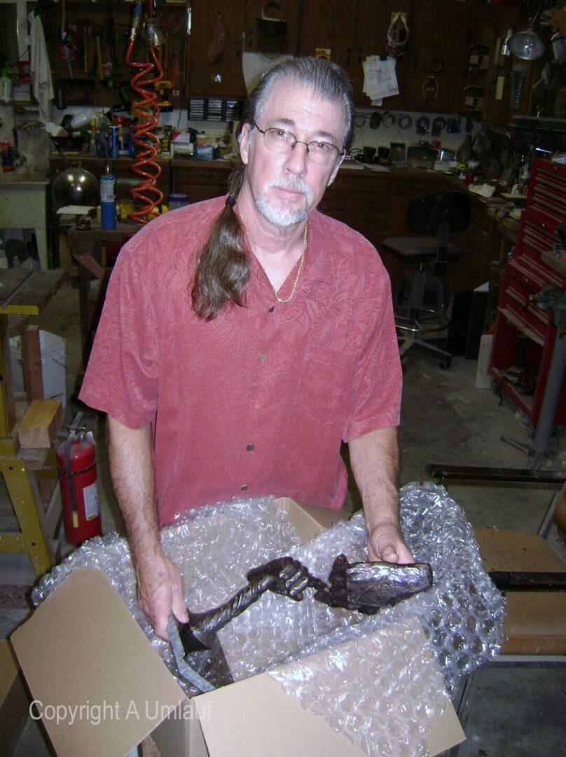 A man holding a ceramic box in a workshop.