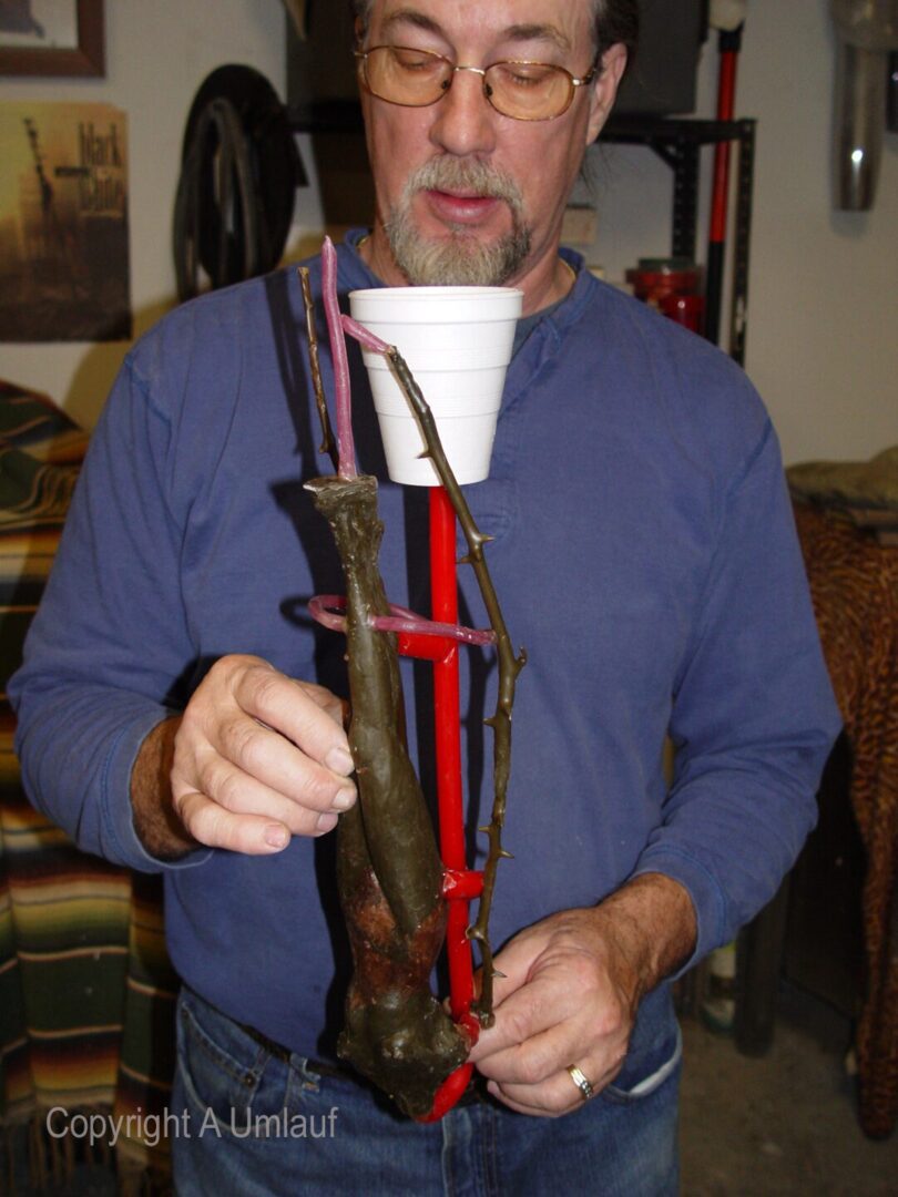 A man holding a trombone created using the investment mold method.