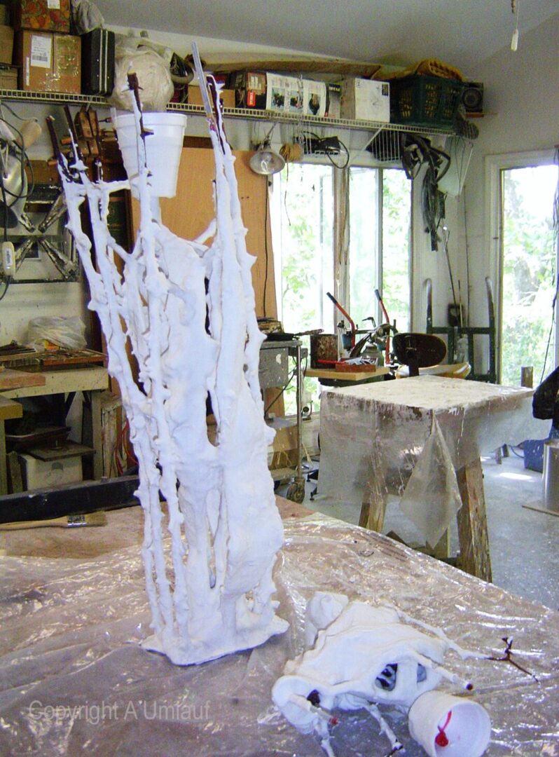 A white vase created using the investment mold method, sitting on a table in a workshop.