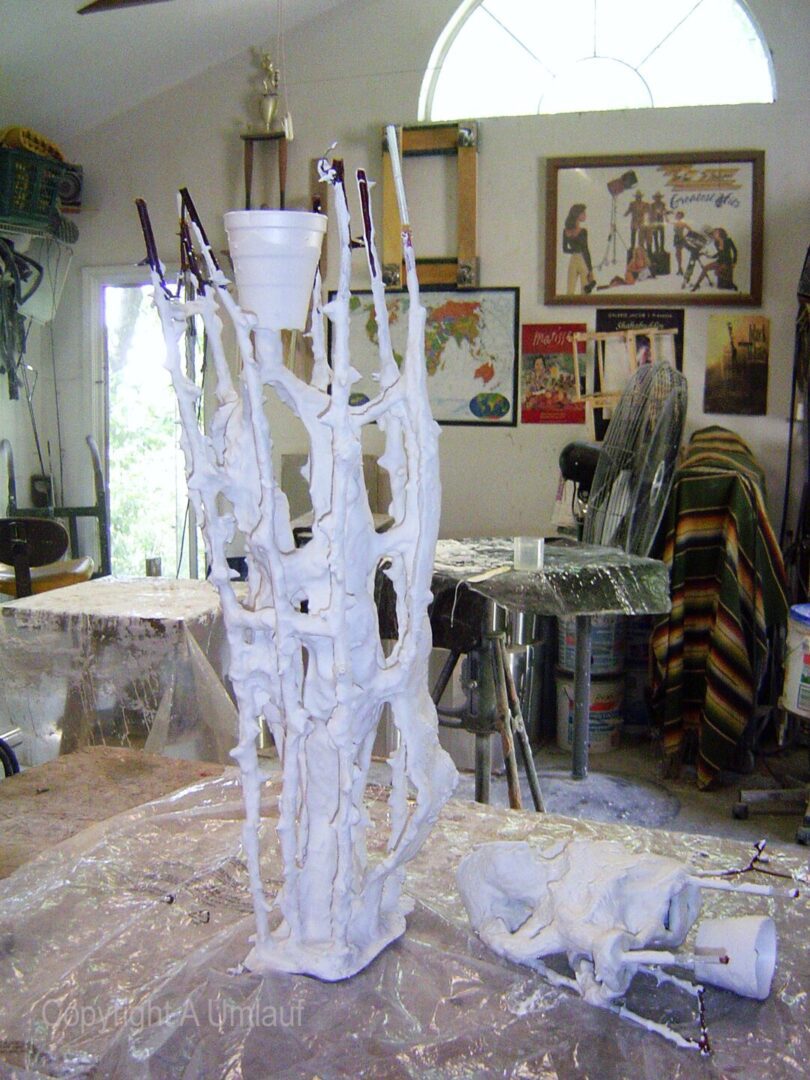 A white vase created using the investment mold method, sitting on a table in a workshop.