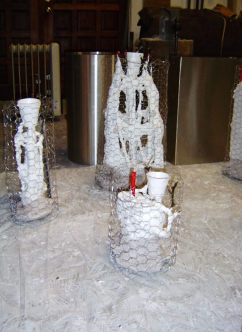 A collection of wire sculptures created using the investment mold method, displayed artfully on a table.
