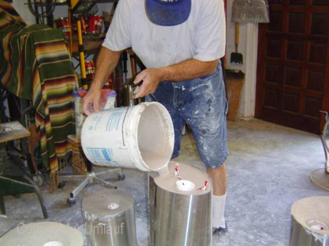 A man using the Investment Mold Method to pour paint into a bucket.