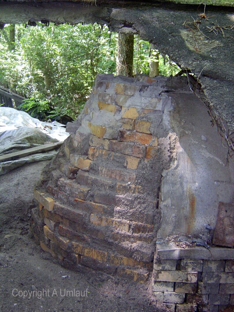 A brick oven utilizing the Investment Mold Method in a serene wooded area.