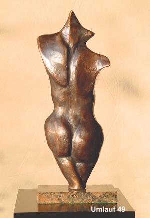 A fine art gallery showcases a mesmerizing bronze sculpture of a woman gracefully seated on a table.