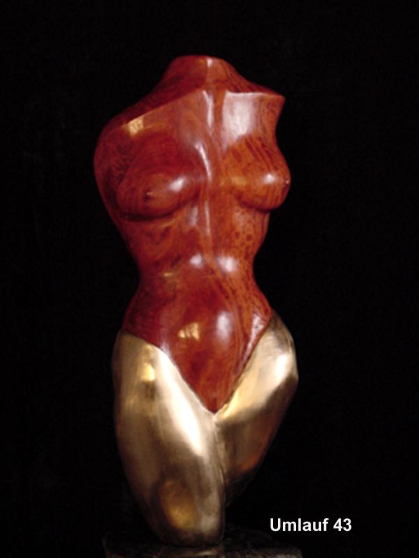 An exquisite sculpture of a woman in red and gold, displayed at an art gallery exhibit.