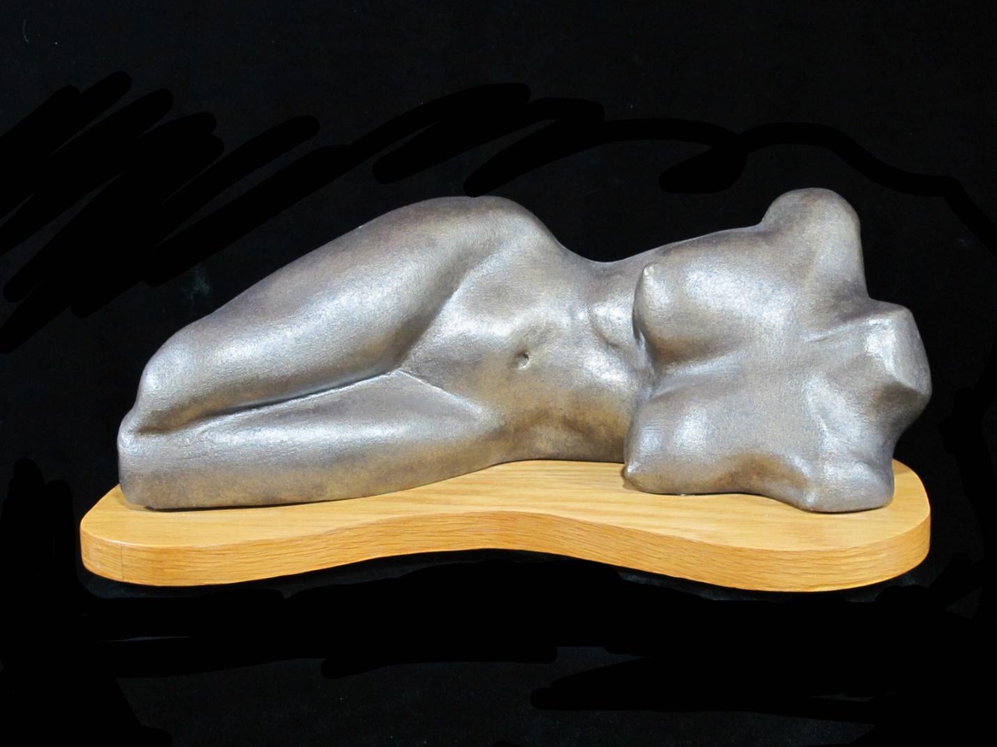 An Umlauf sculpture of a nude sitting on a wooden base.