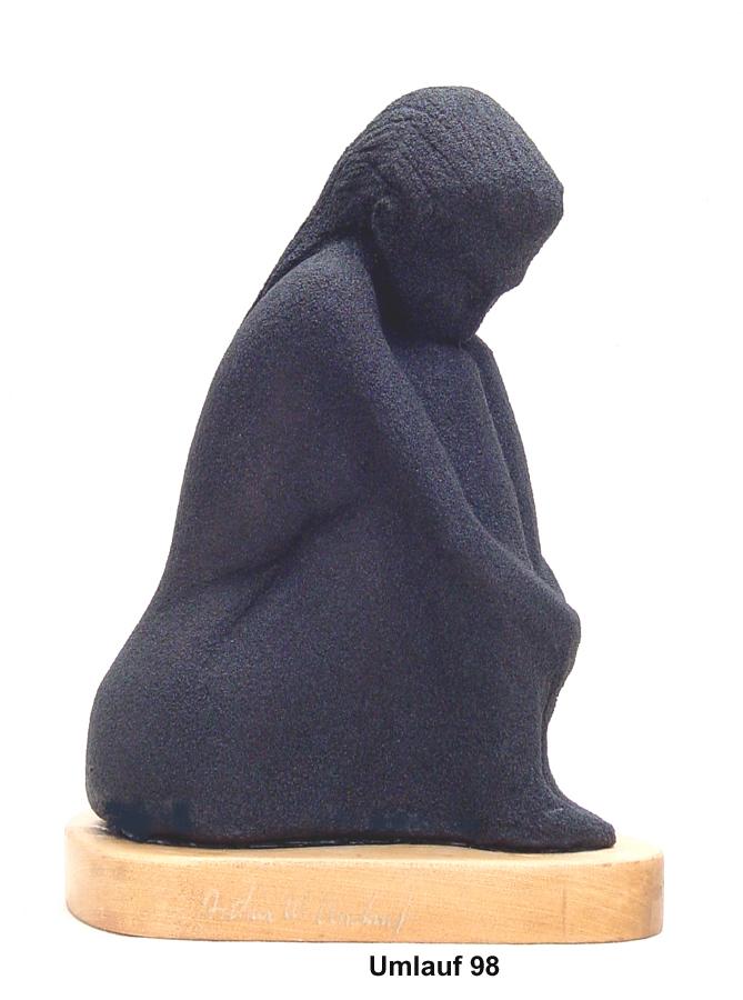 A black sculpture of a woman sitting on a wooden base, part of the Sculpture Collection.