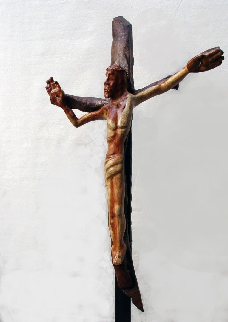 A wooden sculpture of Jesus on a cross, part of a sculpture collection.