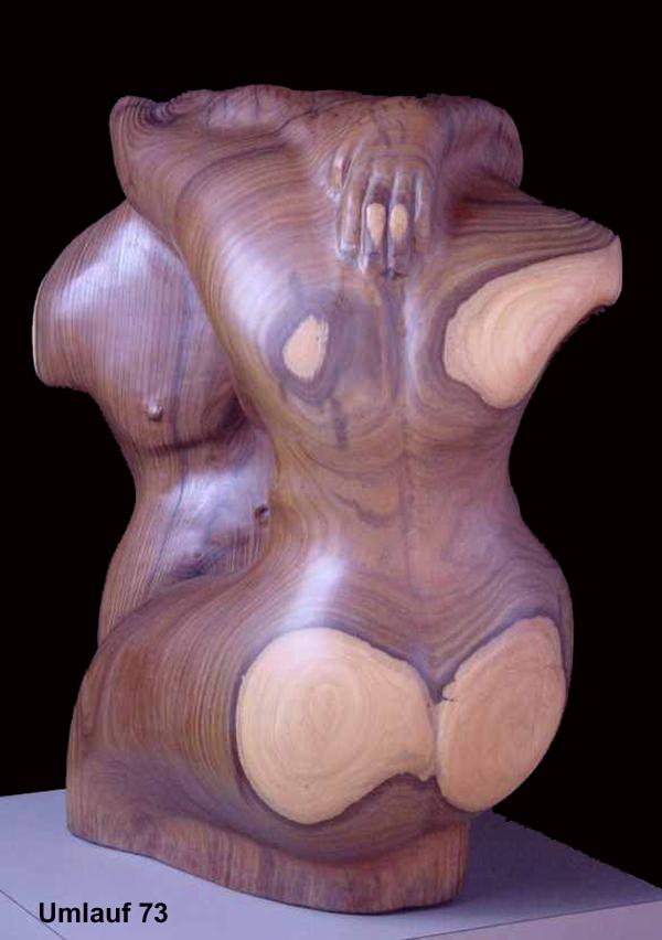 A collection of wooden sculptures featuring a woman and a man.
