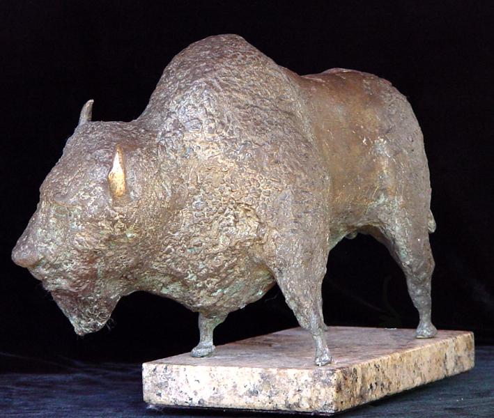 A bronze sculpture of a bison on a wooden base displayed in a Fine Art Gallery.