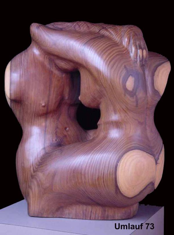 A wooden sculpture of a woman and a man, part of a sculpture collection.