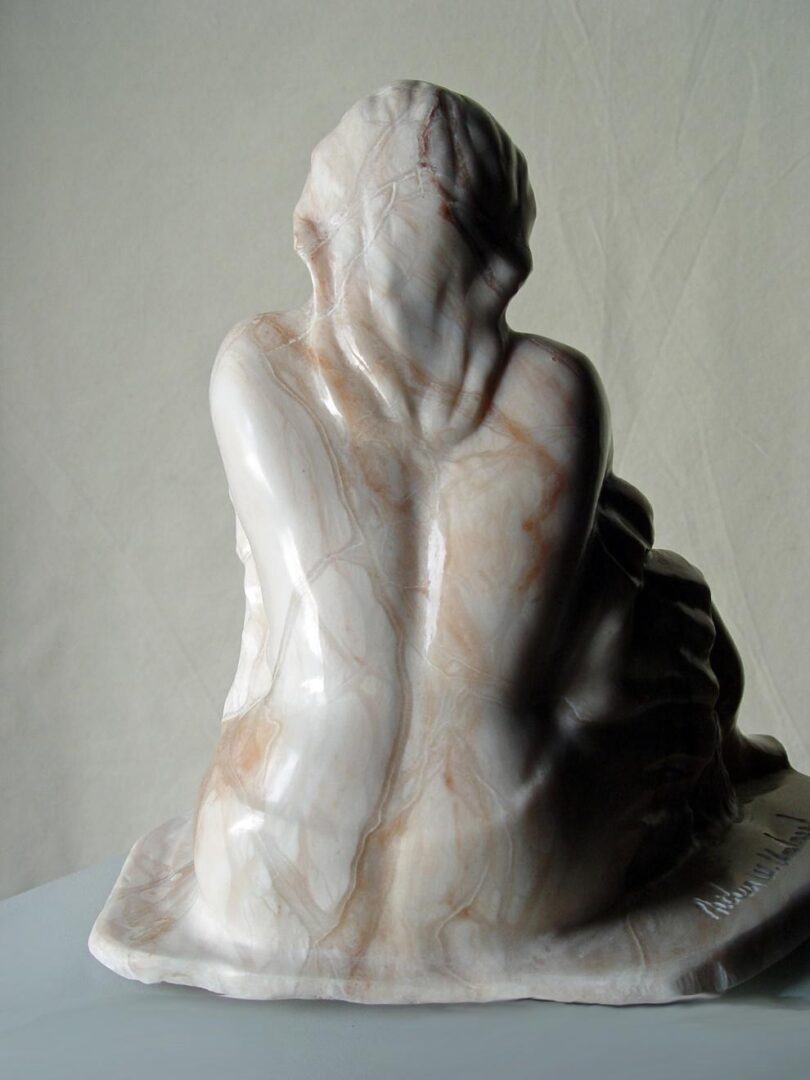 A sculpture of a woman sitting on a table, adding to the Sculpture Collection.
