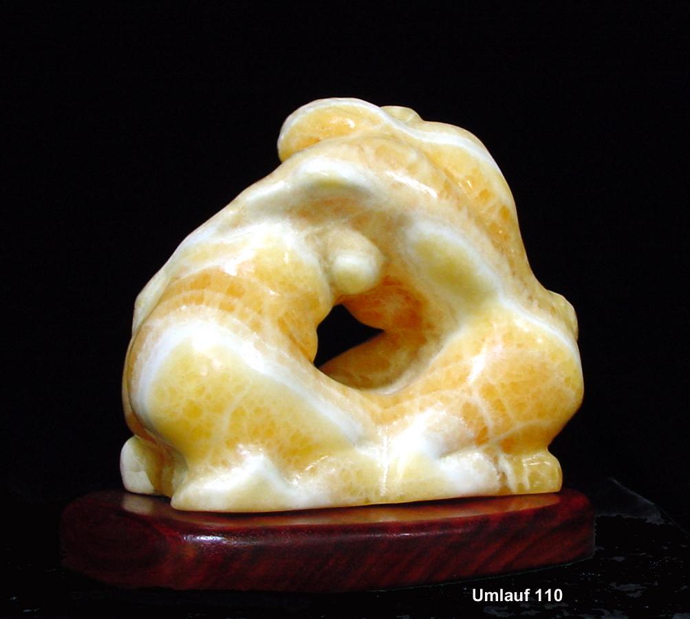 A yellow jade sculpture from the Sculpture Collection on a wooden base.