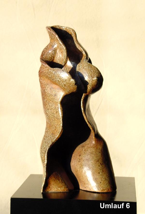 An Umlauf sculpture of a woman sitting on top of a black base.