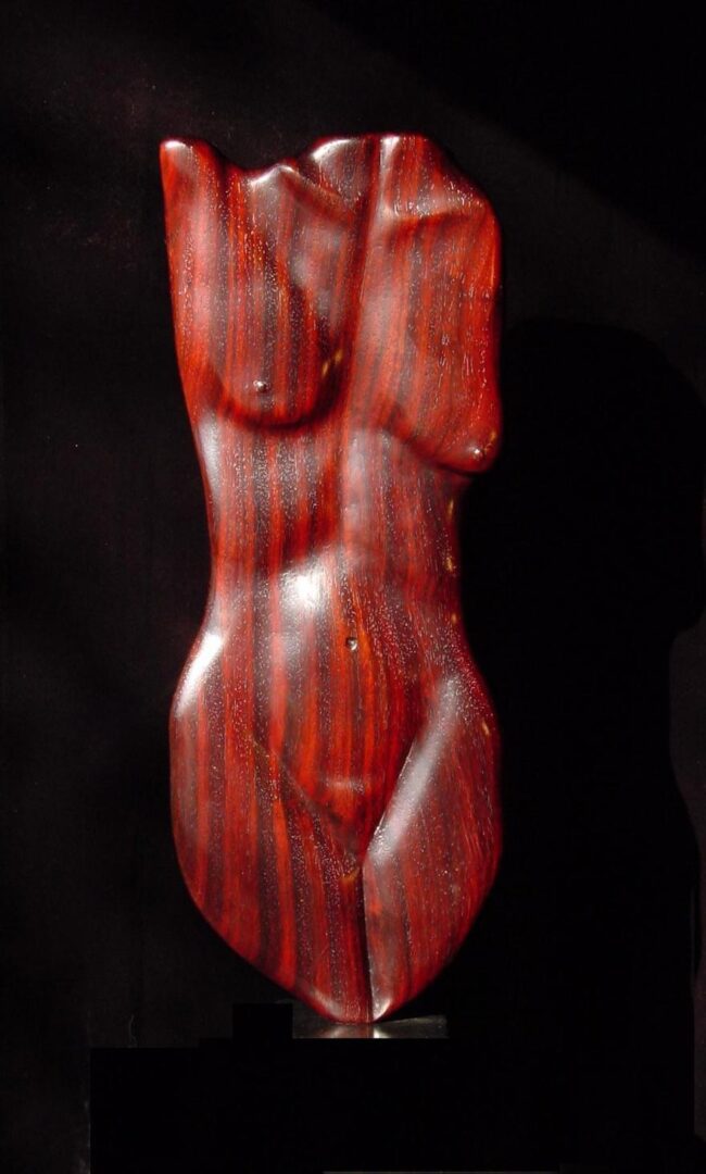 A sculpture collection featuring a stunning woman crafted from vibrant red wood.